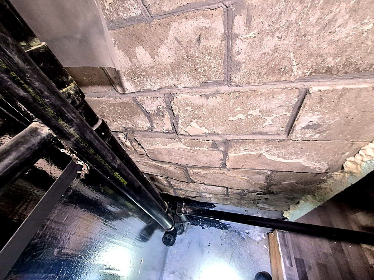 Efflorescence blanchâtre sur les blocs de béton — l'humidité traverse le mur.