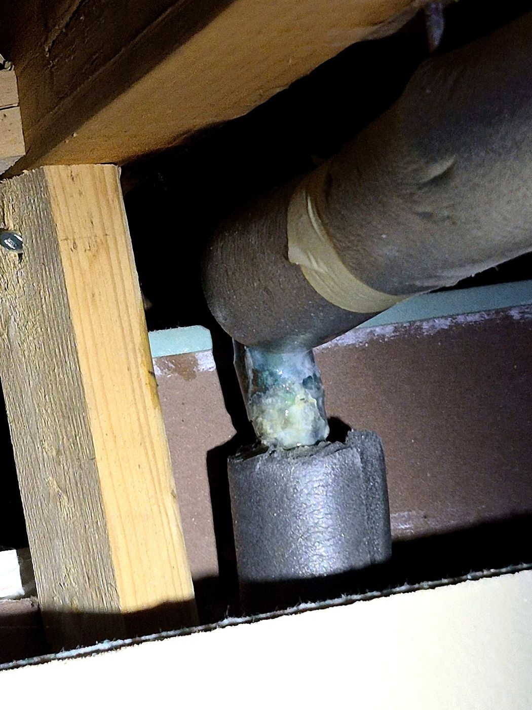Fuite avec présence de vert-de-gris sur un tuyau d'alimentation en cuivre — signe de corrosion active à corriger.